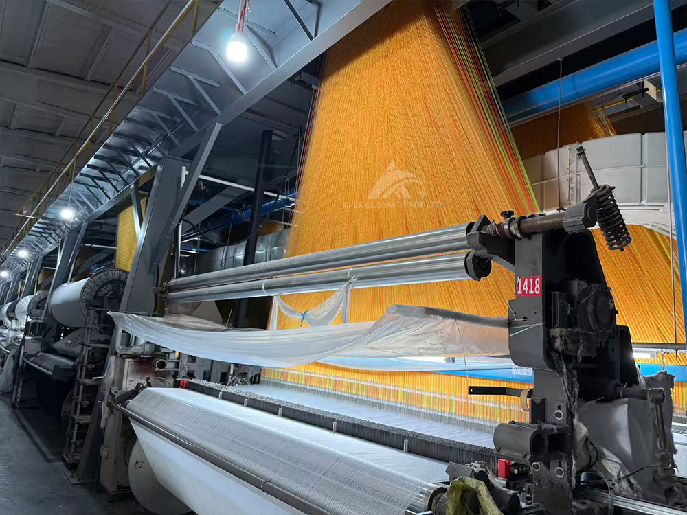 Textile factory workshop producing patterned woven fabric for blankets and home textiles
