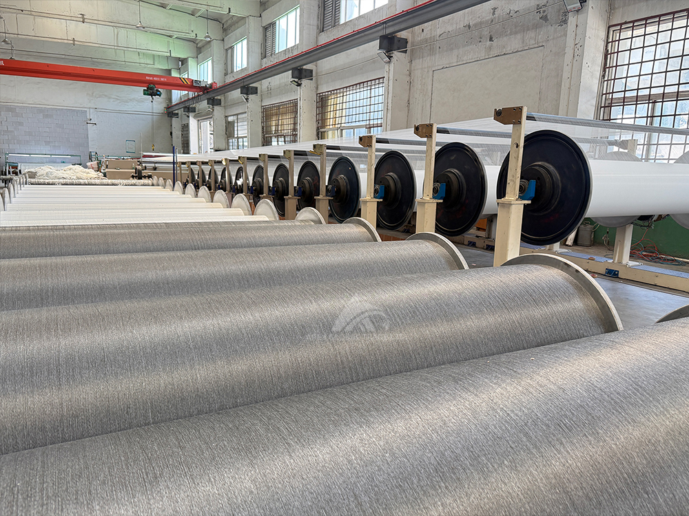 Textile factory workshop with large yarn rolls, raw materials for home textile and blanket production