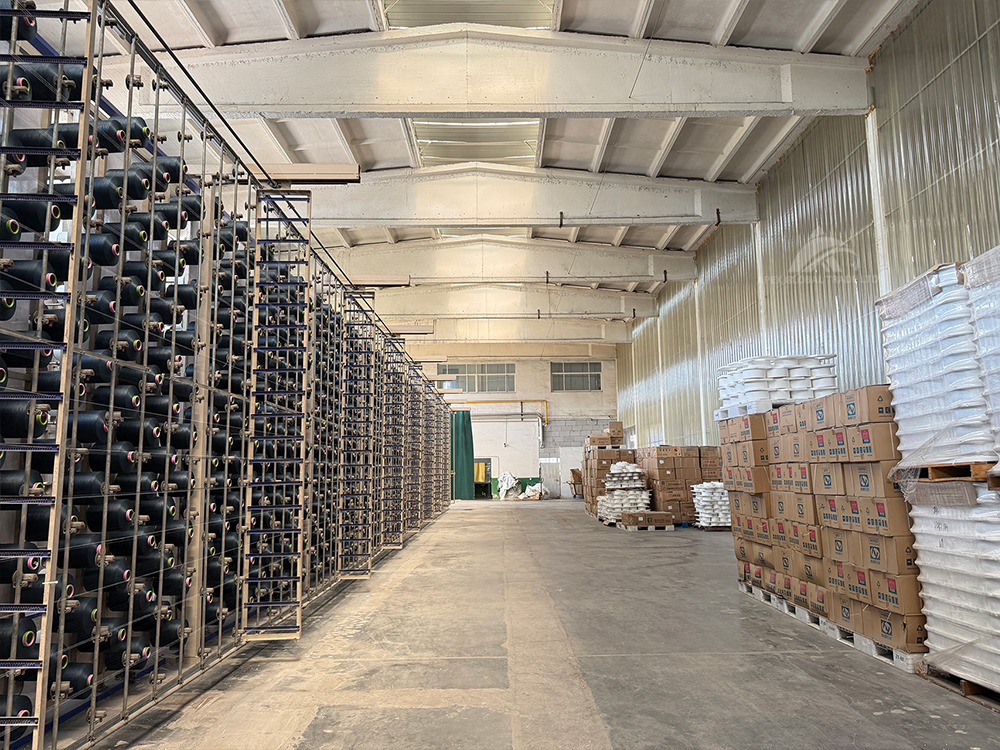Yarn raw material warehouse, spool racks and finished goods stock inside home textile manufacturing factory