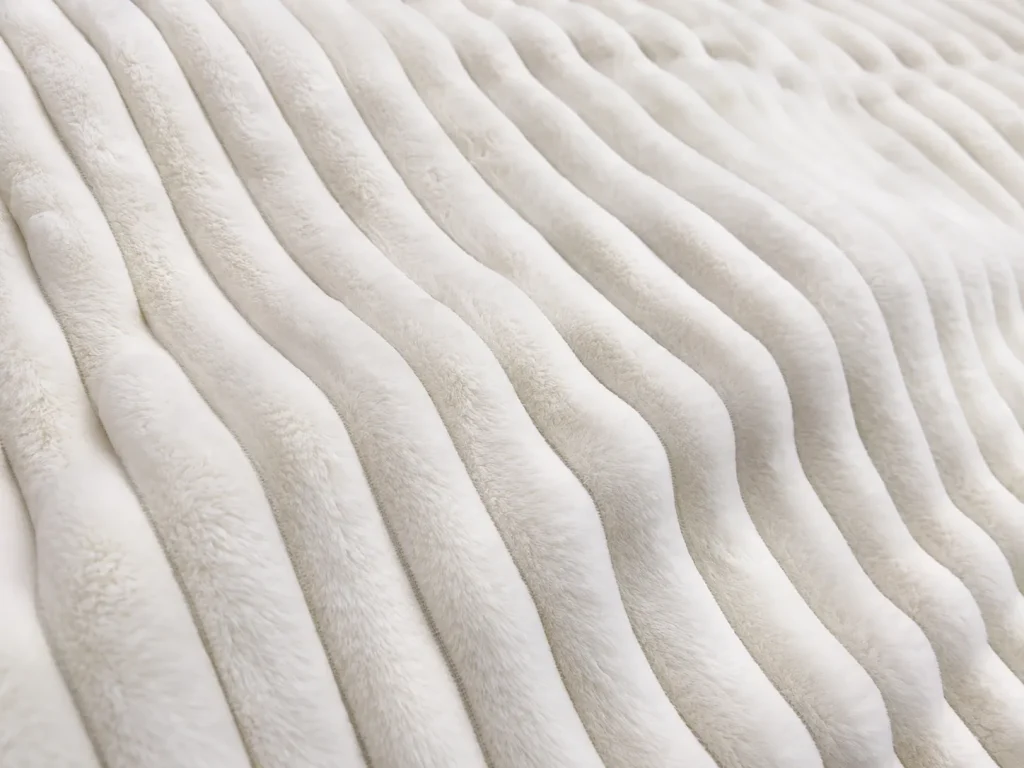 Ribbed faux rabbit fur blanket, macro view of ribbed surface, fluffy home textile blanket